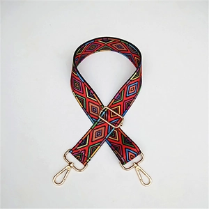 Detailed view of adjustable ethnic geometric woven bag strap with golden buckles
