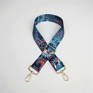 Close-up of ethnic paisley fabric strap with golden alloy hooks and textured weave