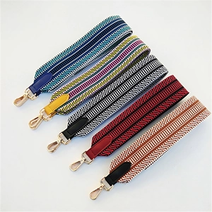 Detailed view of multiple woven shoulder straps with golden hooks and leather ends