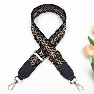 Close-up of a 3.8cm wide embroidered bag strap with geometric patterns and gold buckles