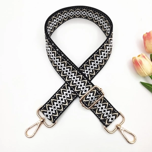 Detail of adjustable woven handbag strap with black and white wavy geometric pattern