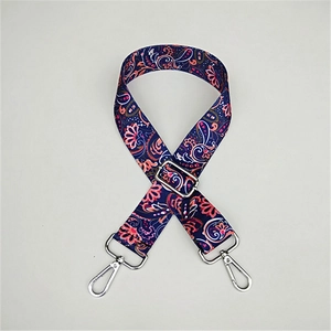 Detail of adjustable paisley canvas shoulder strap with vintage floral pattern and metal hooks