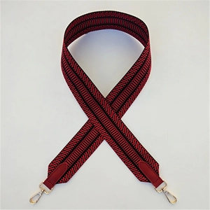 Macro detail of red and black herringbone woven strap with golden swivel lobster clasps