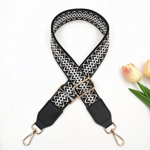 Detail of adjustable embroidered bag strap with ethnic patterns and gold swivel hooks