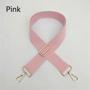 Close-up of pink cotton bag strap with adjustable light gold metal buckles and hardware