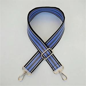 Detail of adjustable wide striped canvas bag strap with gold metal hooks for handbags