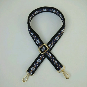 Detail of adjustable geometric snowflake jacquard strap with gold metal buckles