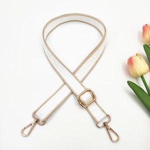 Detail of adjustable maze pattern bag strap with golden metal lobster clasps