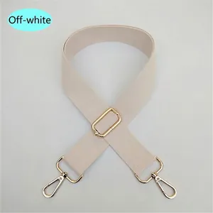 Detalle de correa ajustable de algodón blanco crema con ganchos de metal dorado