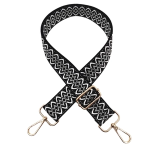 Adjustable black and white geometric woven shoulder strap with gold metal hooks and buckles