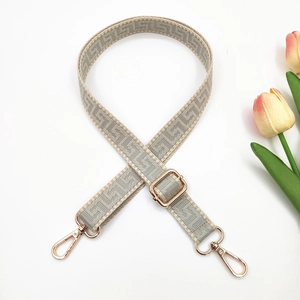 Close-up of adjustable 2.5cm maze jacquard bag strap with gold metal hooks on white background