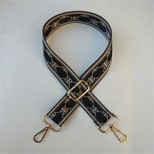 Close-up of adjustable wide woven bag strap with grey stripes and gold lobster clasps