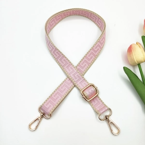 Detailed close-up of pink and beige jacquard strap with gold-tone metal hooks