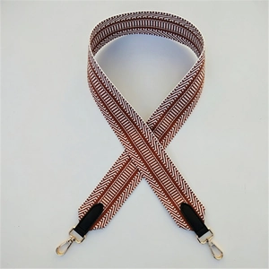 Macro shot of geometric twill fabric strap with golden metal swivel hooks and leather ends