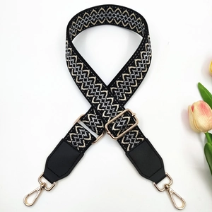 Detail of adjustable geometric jacquard shoulder strap with gold metal hardware and hook