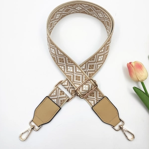 Detail of bohemian geometric embroidered bag strap with golden metal lobster clasps