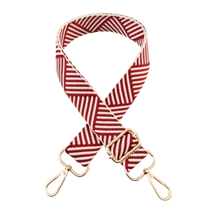 Detail of red and white diagonal striped bag strap with gold adjustable metal hooks