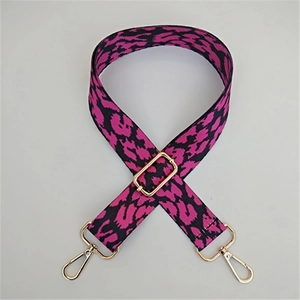 Détail de la bandoulière tissée léopard rose et noir avec mousquetons dorés