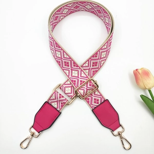Detail of colorful jacquard strap with geometric diamond patterns and golden metal buckles
