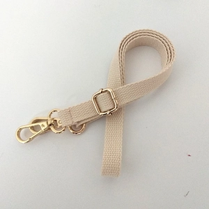 Close-up of beige woven replacement strap with adjustable golden metal buckle and clasp