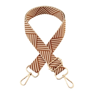 Detail of adjustable woven bag strap with brown chevron pattern and gold metal hardware