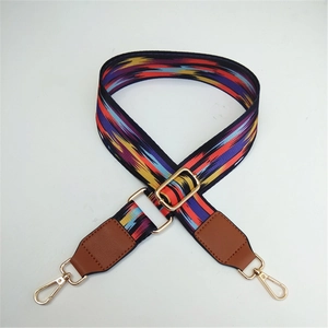 Close-up of adjustable ethnic style woven bag strap with colorful patterns and gold hooks