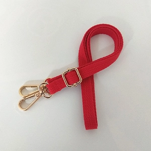 Close-up of adjustable red canvas shoulder strap with polished gold metal lobster clasps