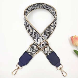 Detail of woven bag strap with diamond pattern and gold-tone lobster clasps