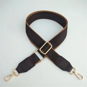 Detailed view of adjustable wide shoulder strap with golden metal lobster clasps and buckles