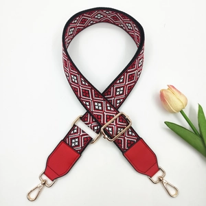 Close-up of ethnic embroidered bag strap with geometric patterns and golden metal buckles