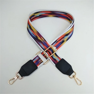 Detail showing the colorful abstract stripes and golden metal clasps of the bag strap