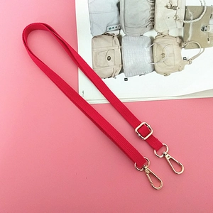 Detail of red nylon shoulder strap with gold metal hooks and adjustable buckle for bags