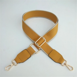 Adjustable mustard yellow canvas bag strap with gold metal buckles and white stitching