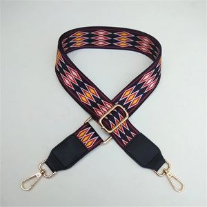 Detail of colorful geometric ethnic bag strap with golden metal lobster clasps