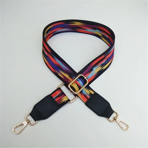 Macro shot of ethnic style colorful woven handbag strap with golden metal swivel hooks