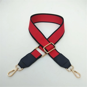 Detailed view of red contrast wide strap with gold buckle and black leather end