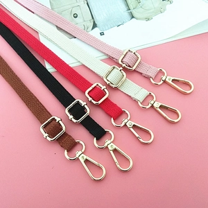 Detail showing colorful woven canvas straps with gold metal buckles and swivel hooks