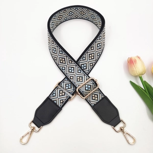 Detail of bohemian jacquard bag strap with geometric pattern and gold hardware