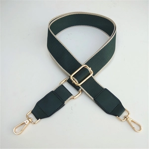 Close-up of adjustable dark green canvas shoulder strap with gold metal hardware and lobster clips