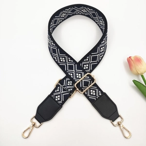 Detail of blue and white ethnic geometric embroidery on adjustable bag strap with gold hooks
