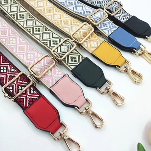 Detailed view of colorful jacquard guitar style bag straps with gold metal hooks