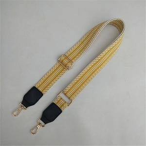 Adjustable woven bag strap with yellow chevron pattern and gold metal buckles