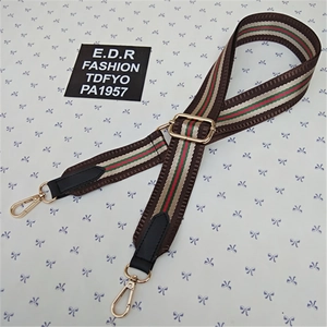 Detail of adjustable nylon strap with green and red stripes and gold lobster clasps