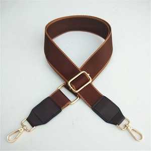 Adjustable brown nylon crossbody strap with faux leather ends and gold metal buckles