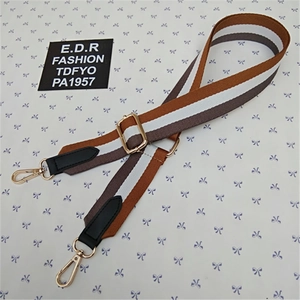 Detail of adjustable striped bag strap with gold lobster clasps and leather trim