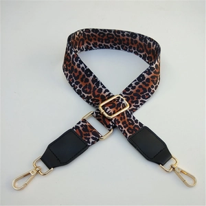 Detail of adjustable leopard print bag strap with gold metal hooks and black leather ends