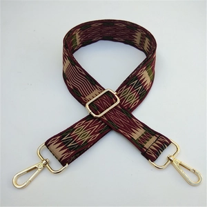 Close-up of ethnic style woven bag strap with geometric patterns and gold metal lobster clasps