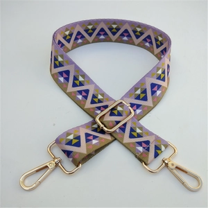 Detail of colorful geometric woven shoulder strap with gold metal buckles and adjuster