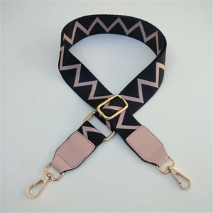 Detail of wide adjustable shoulder strap with pink zigzag pattern and gold lobster clasp
