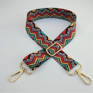Close-up of colorful ethnic geometric woven strap with golden metal swivel hooks
